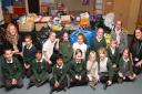 Volunteers Annabelle Beeson, Tanya Rickard and Louise Calder with pupils of Bowmansgreen Primary School sit with donations made by the school's pupils to the Red Cross aid effort in the Philippines