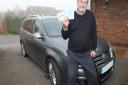 Julian Davis with his car and blue badge parking permit