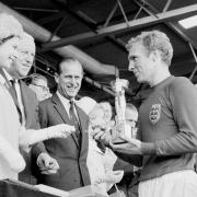 Queen Elizabeth II hands over the Jules Rimet Trophy to England captain Bobby Moore in 1966.