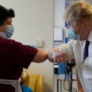 Prime Minister Boris Johnson bumps elbows as a greeting with a member of the nursing team during a visit to the New Queen Elizabeth II Hospital.
