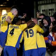 Mitchell Weiss is mobbed by team-mates after scoring the first goal for St Albans City on a historic night in the FA Cup against Forest Green Rovers.