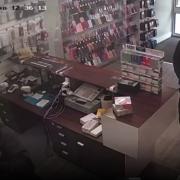 A CCTV video shows one of the intruders grab Muhammed, whilst another takes phones from his shop.