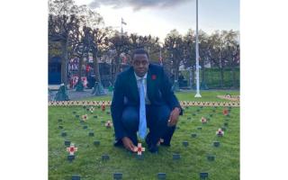 Bim Afolami places a Remembrance Cross in Parliament's Constituency Garden of Remembrance.